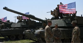 American soldiers stand near Abrams tanks bearing the U.S. flag before the opening ceremony of joint multinational military exercises outside Tbilisi, in the nation of Georgia in July 2017.
