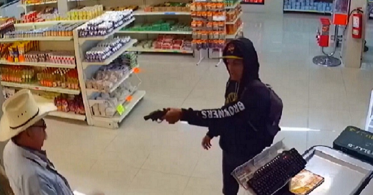 Criminal holds gun on man in convenience store.