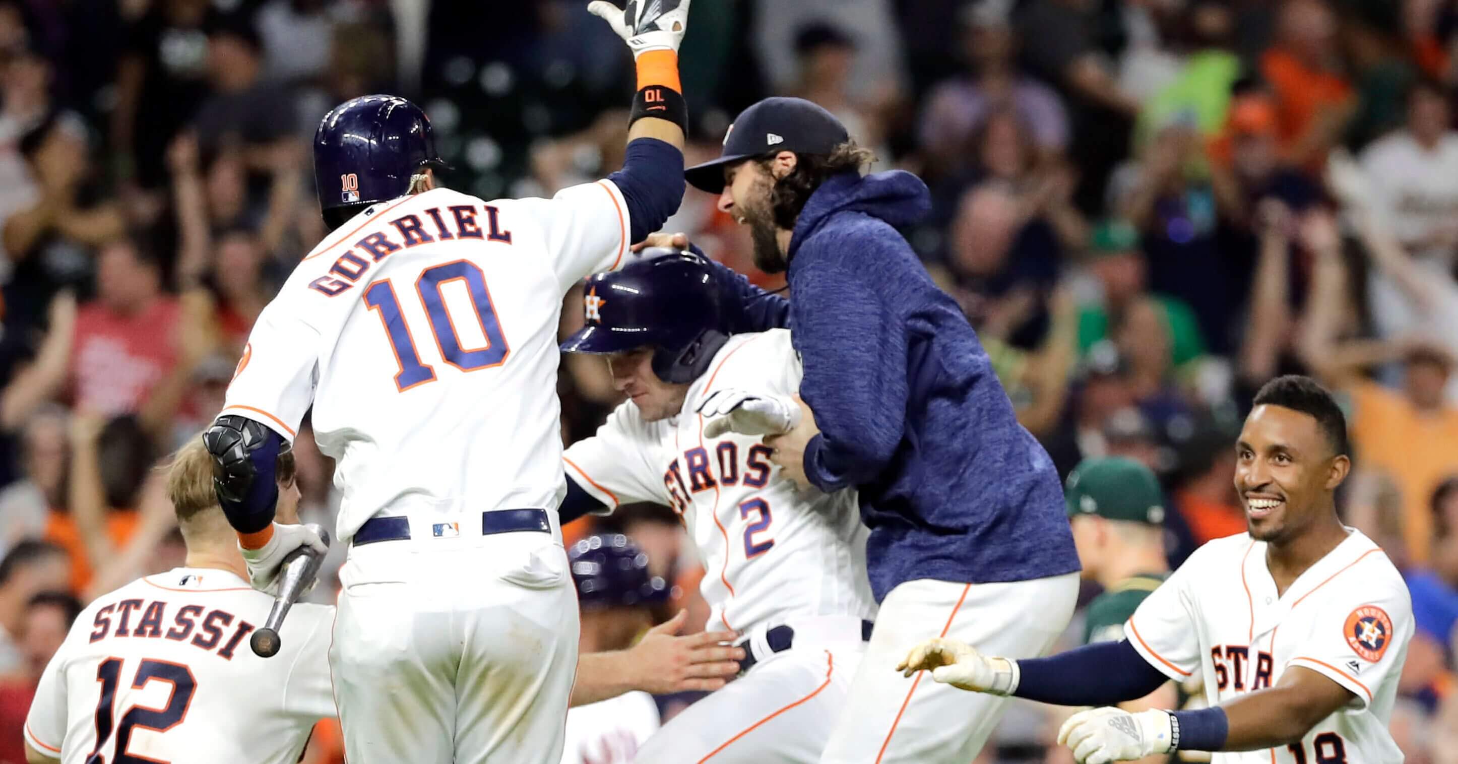 Houston Astros' Alex Bregman (2) celebrates with teammates after hitting a ground ball to Oakland Athletics catcher Jonathan Lucroy to score Kyle Tucker during the 11th inning of a baseball game Tuesday, July 10, 2018, in Houston. The Astros won 6-5.