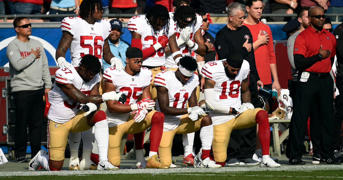 Several members of the San Francisco 49ers kneel during the anthem prior to the football game against Los Angeles Rams at Los Angeles Memorial Coliseum on December 31, 2017 in Los Angeles.
