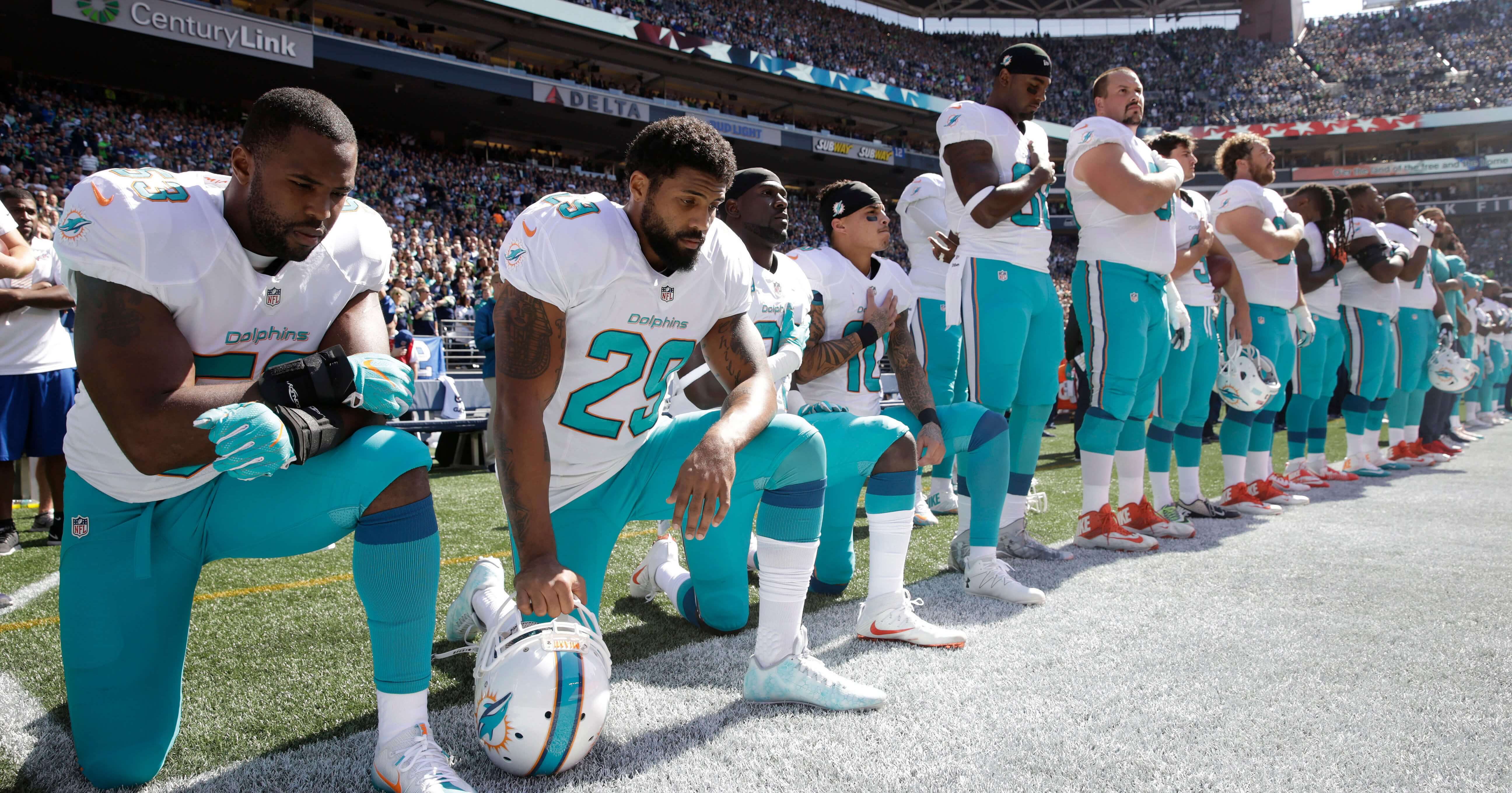 Members of the Miami Dolphins take a knee to protest the national anthem during a 2017 game