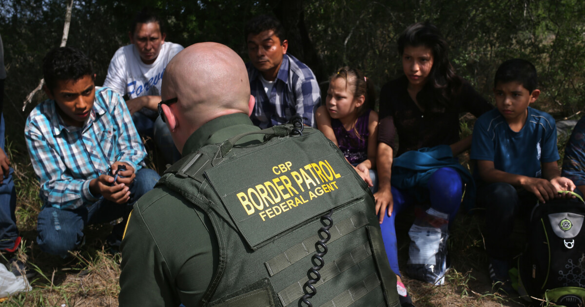 A Border Patrol agent speaks with Central American immigrant families who crossed into the United States seeking asylum on April 14, 2016, in Roma, Texas.