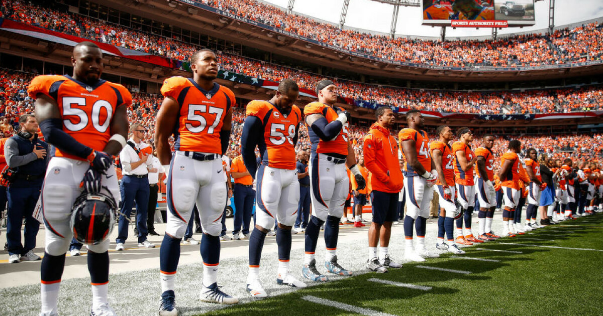 Denver Broncos players and staff during the national anthem prior to a 2017 game in Denver