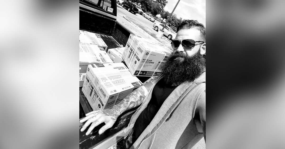 Chad Foster poses with air conditioners he bought for the poor.