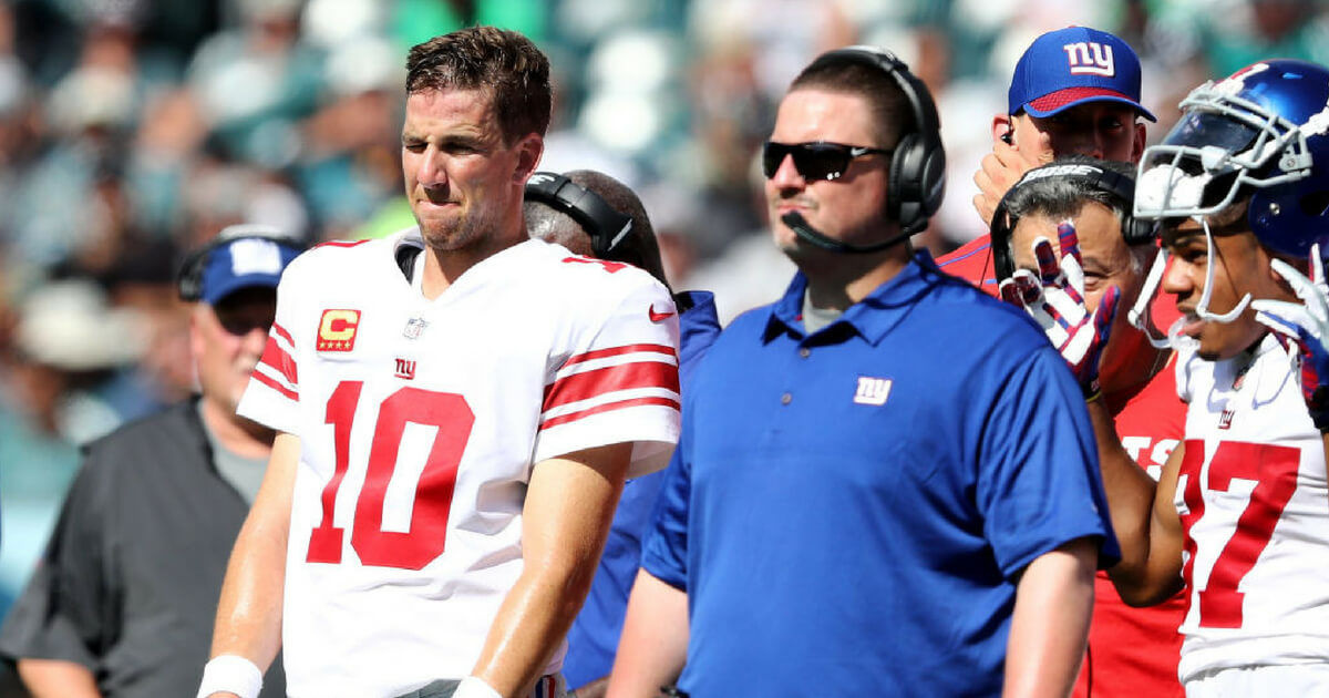 Quarterback Eli Manning and head coach Ben McAdoo look on from the sidelines during a 2017 game between the Gians and Eagles