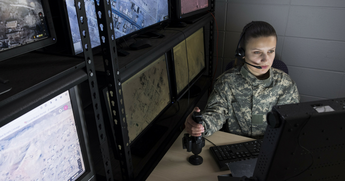 Female military drone operator in computer room