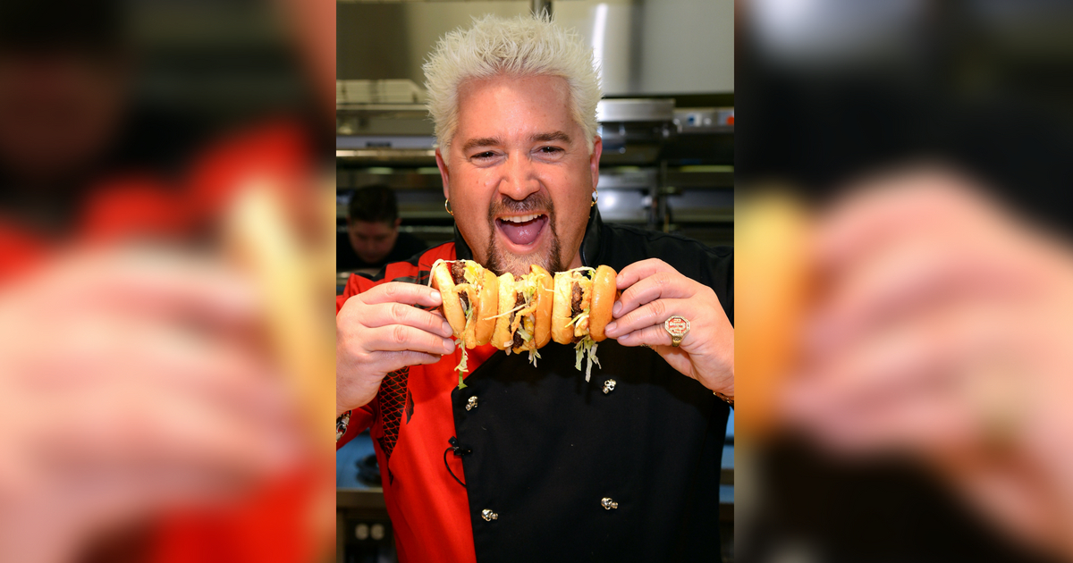 LAS VEGAS, NV - APRIL 04: Chef and television personality Guy Fieri holds hamburgers in the kitchen during a welcome event for Guy Fieri's Vegas Kitchen & Bar at The Quad Resort & Casino on April 4, 2014 in Las Vegas, Nevada. The restaurant opens on April 17.