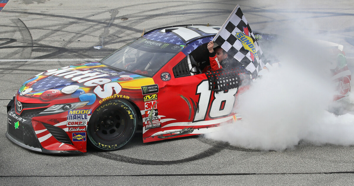 Kyle Busch, driver of the #18 Skittles Red White & Blue Toyota, celebrates with a burnout after winning the Monster Energy NASCAR Cup Series Overton's 400 at Chicagoland Speedway on July 1, 2018 in Joliet, Illinois.