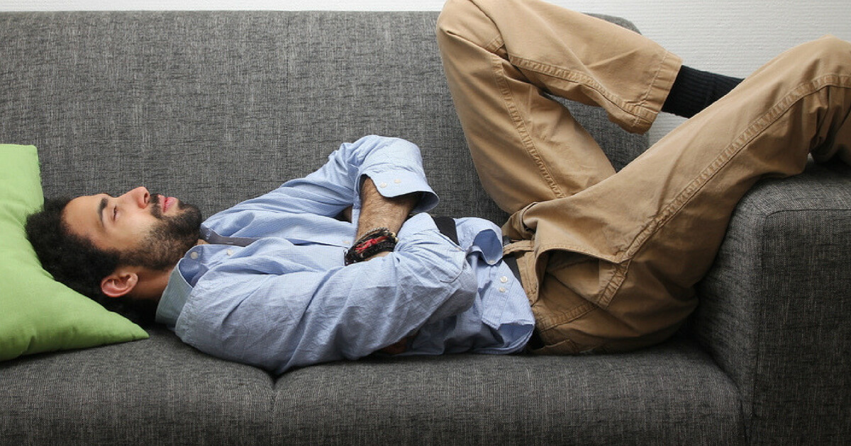 A lazy man laying on a couch