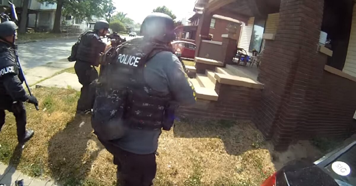 Armed police officers heading into a home
