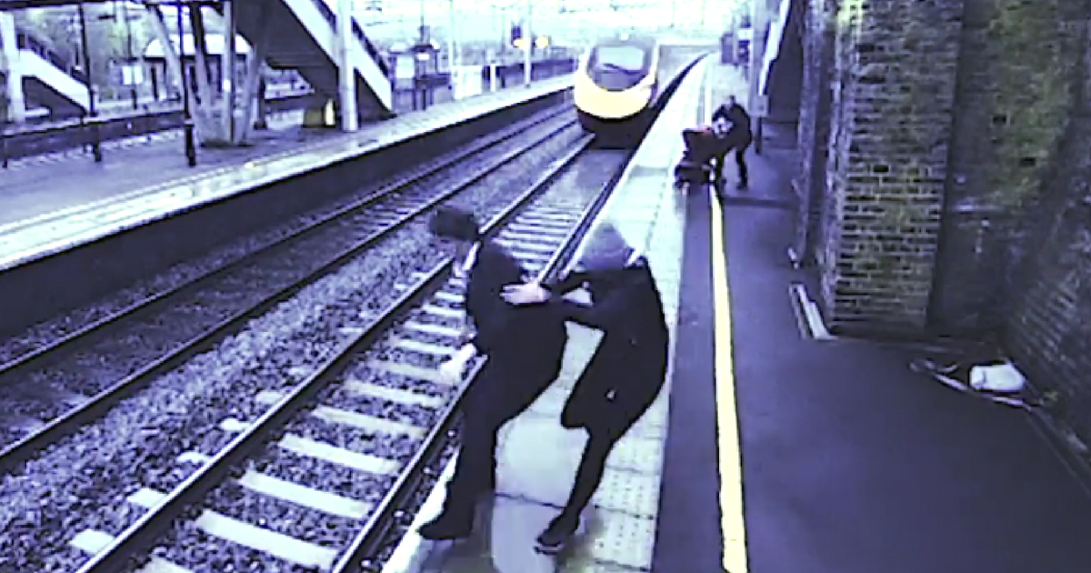 A woman saves a man from jumping in front of a train.