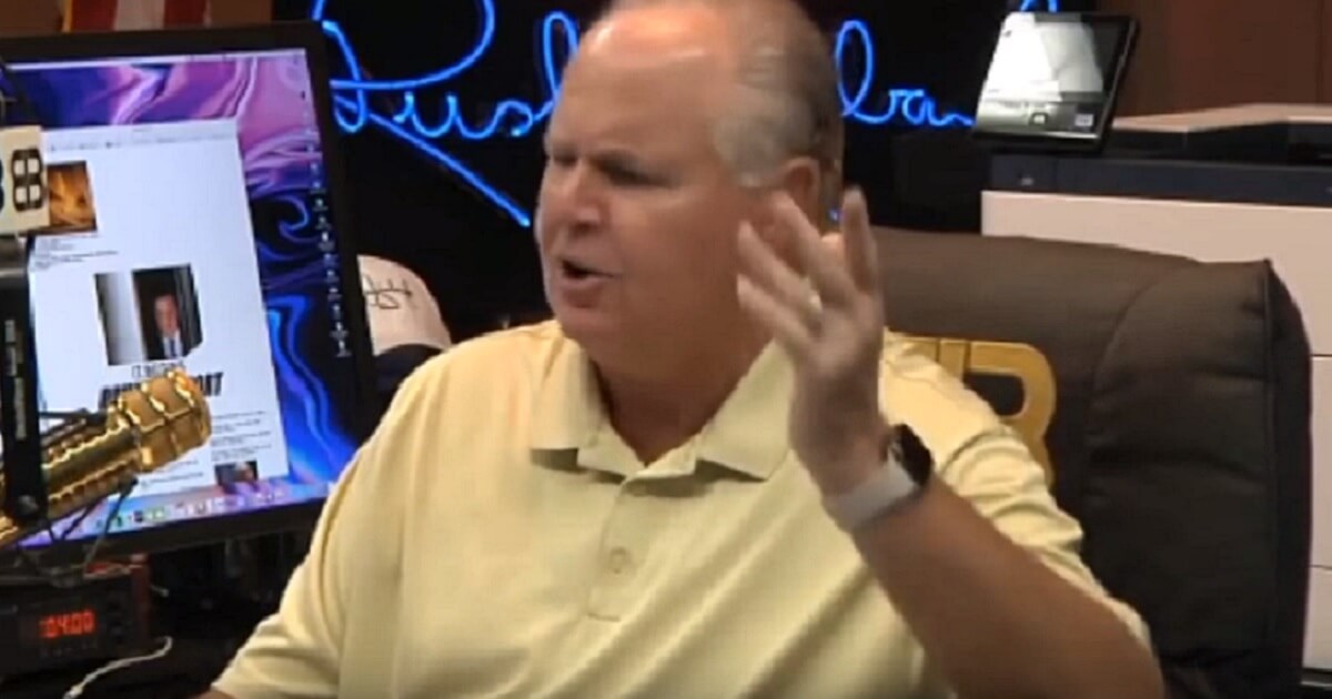 Rush Limbaugh gestures while speaking into a microphone.