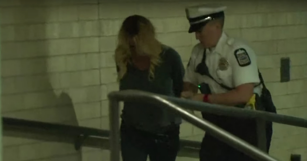 Stormy Daniels led by police officer in handcuffs