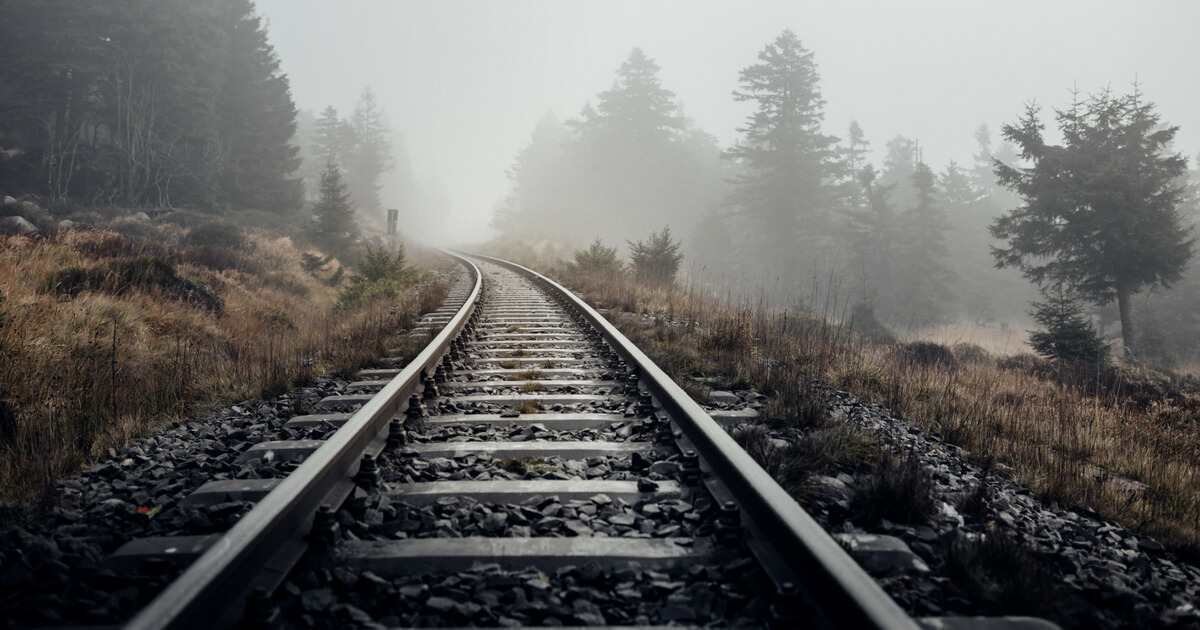 train tracks leading off into the fog