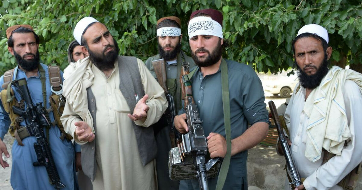 Afghan Taliban militants stand with residents as they took to the street to celebrate ceasefire on the second day of Eid in the outskirts of Jalalabad on June 16,2018.