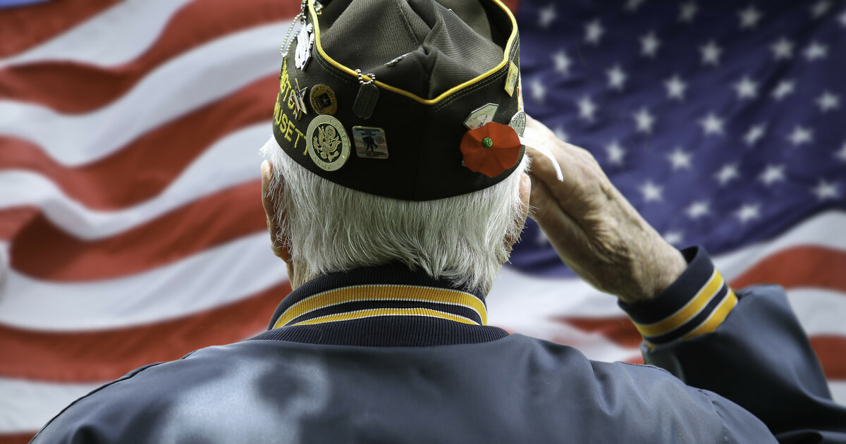 Veteran saluting in front of US flag