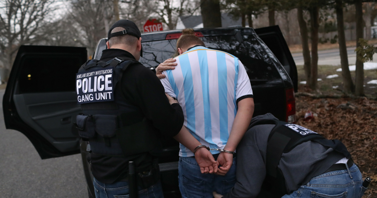 ICE agents frisk a suspected MS-13 gang member