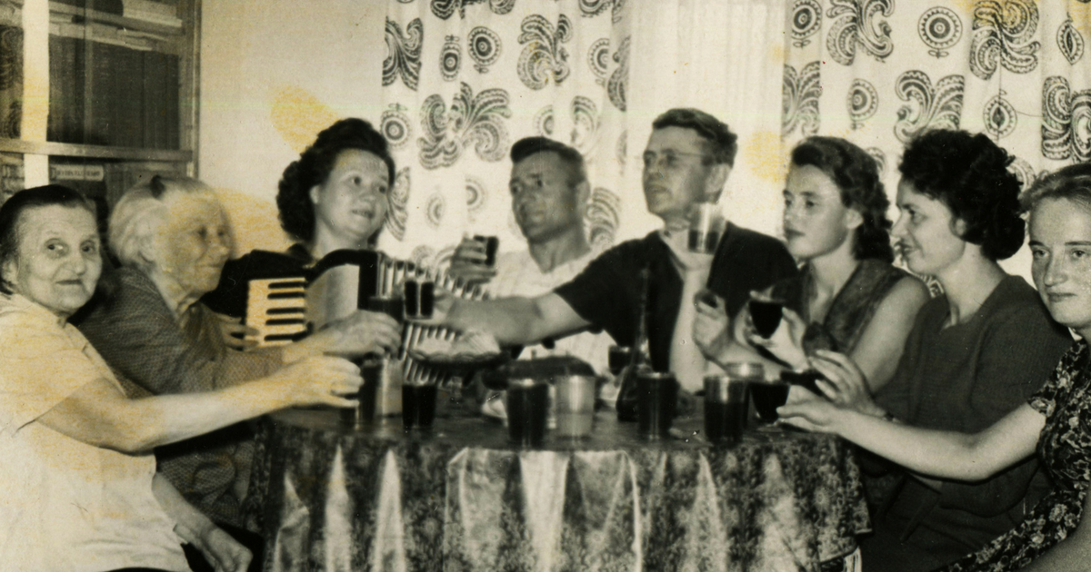 Old black and white photograph of people sitting around the table
