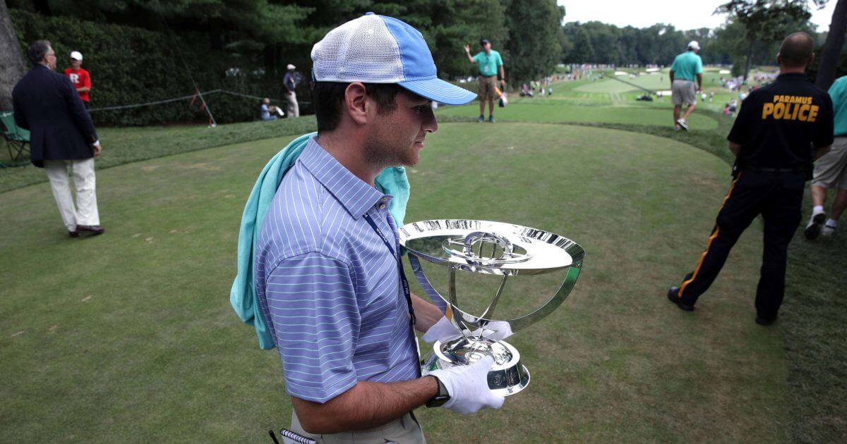 Zach Rosen carries the winner's trophy from the first tee box during the final round of the Northern Trust golf tournament, Sunday, Aug. 26, 2018, in Paramus, N.J.