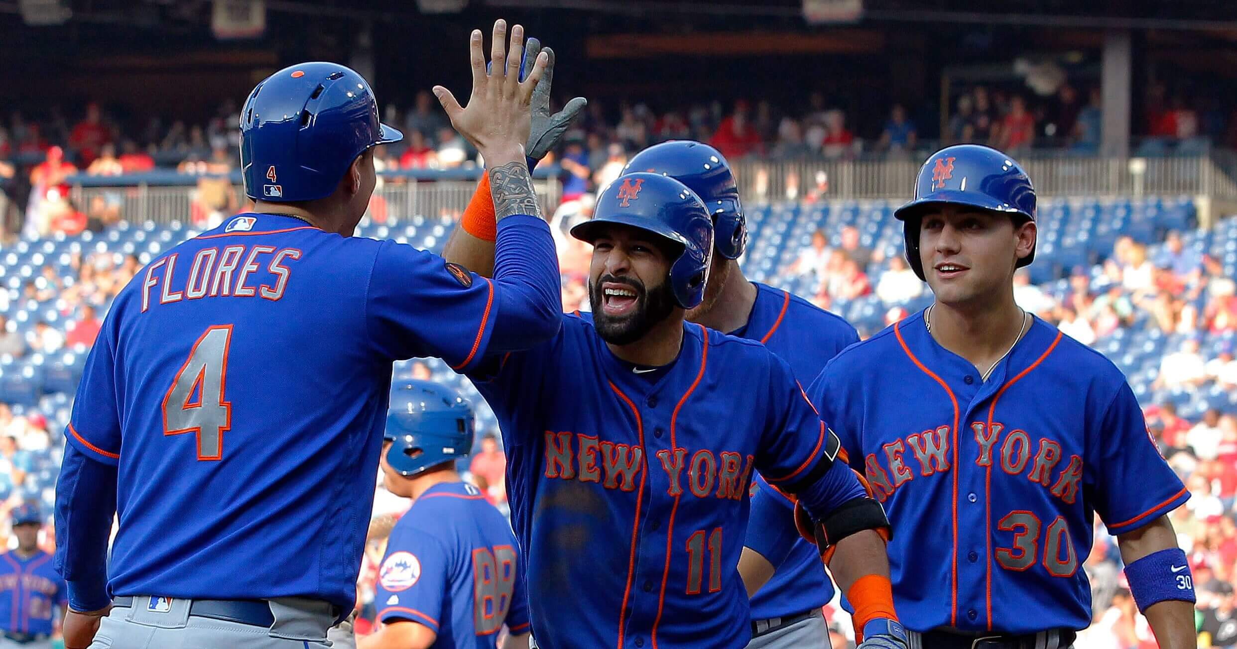 New York Mets' Jose Bautista, center, high-fives Wilmer Flores after Bautista hit a grand slam during the fifth inning of a baseball game against the Philadelphia Phillies on Thursday in Philadelphia.
