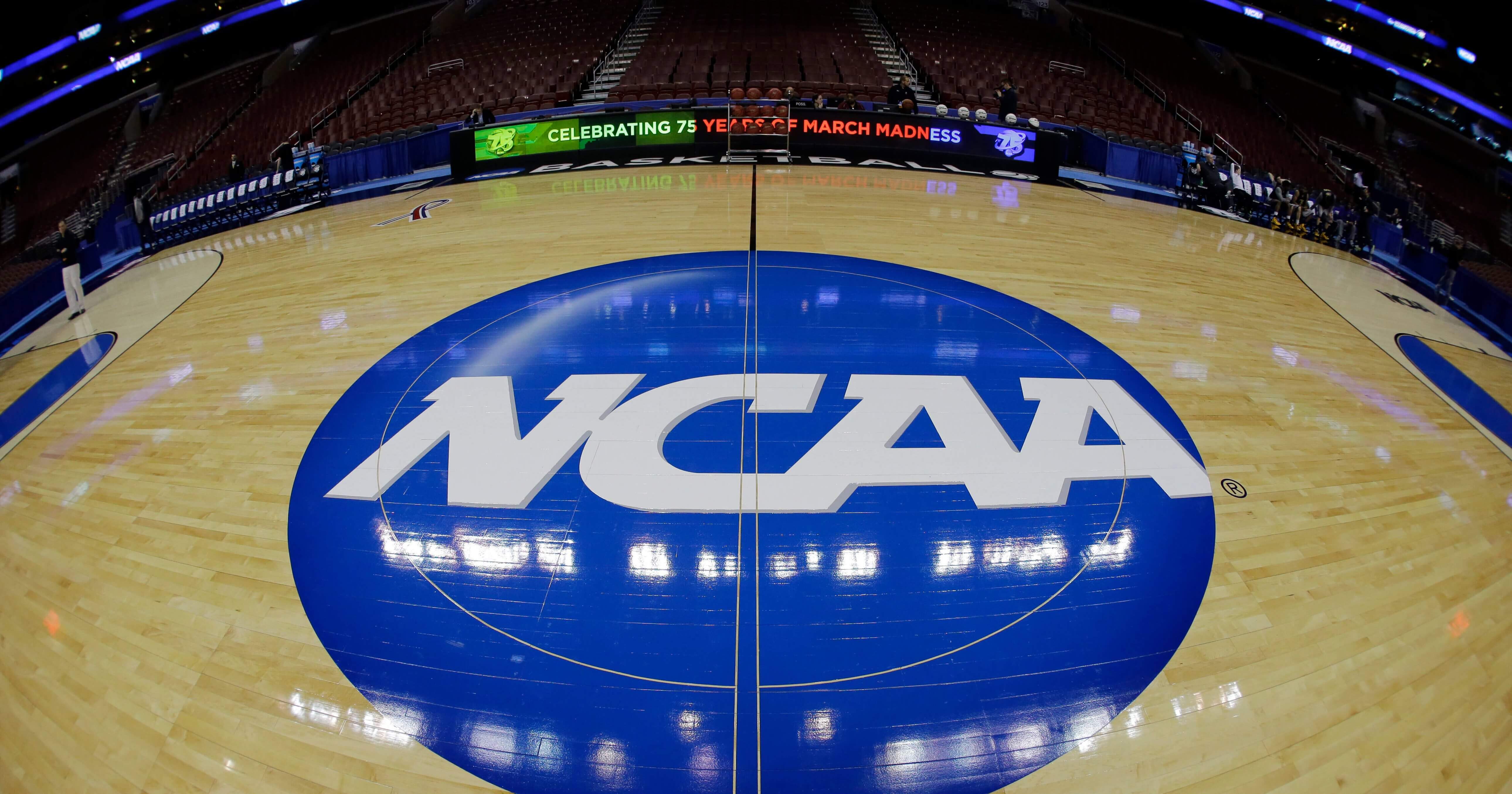 In this March 21, 2013, file photo, taken with a fisheye lens, the NCAA logo is displayed on the court during the NCAA college basketball tournament in Philadelphia.