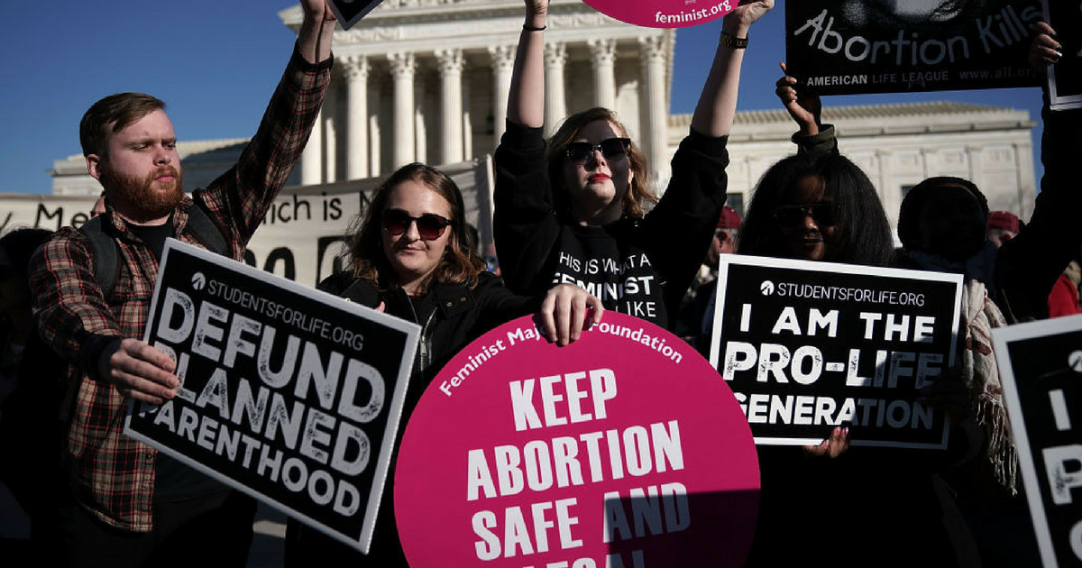 Pro-life activists try to block the signs of pro-choice activists in front of the the U.S. Supreme Court during the 2018 March for Life January 19, 2018 in Washington, DC.