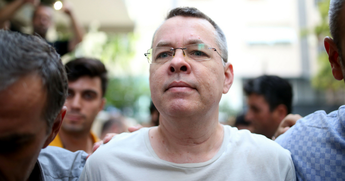 Pastor Andrew Craig Brunson (R), escorted by Turkish plain clothes police officers as he arrives at his house on July 25, 2018 in Izmir. - A Turkish court on July 25, 2018 ruled to place under house arrest an American pastor who has been imprisoned for almost two years on terror-related charges in a case that has raised tensions with the United States, state media said. The state-run Anadolu news agency said he was being put under house arrest, although it was not clear if he had already left prison.