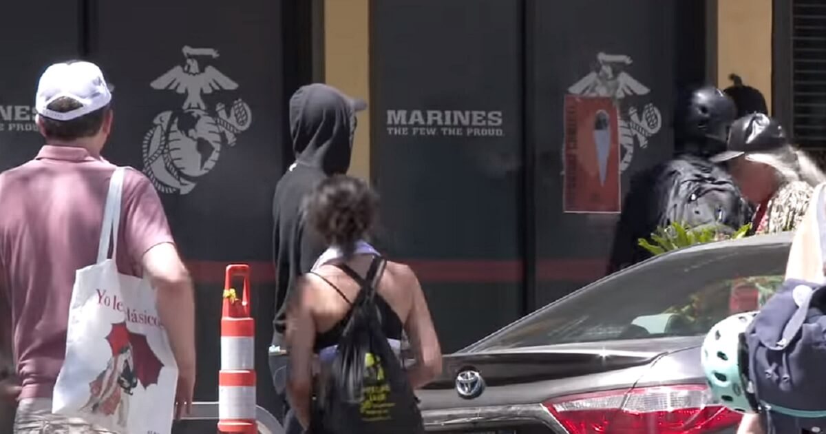 Thugs outside an office with the word "Marines" on the window