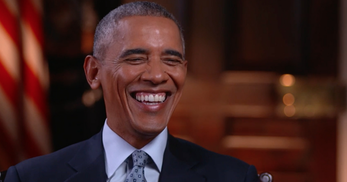 Former president Barack Obama laughs during in an interview with HBO's Bill Maher