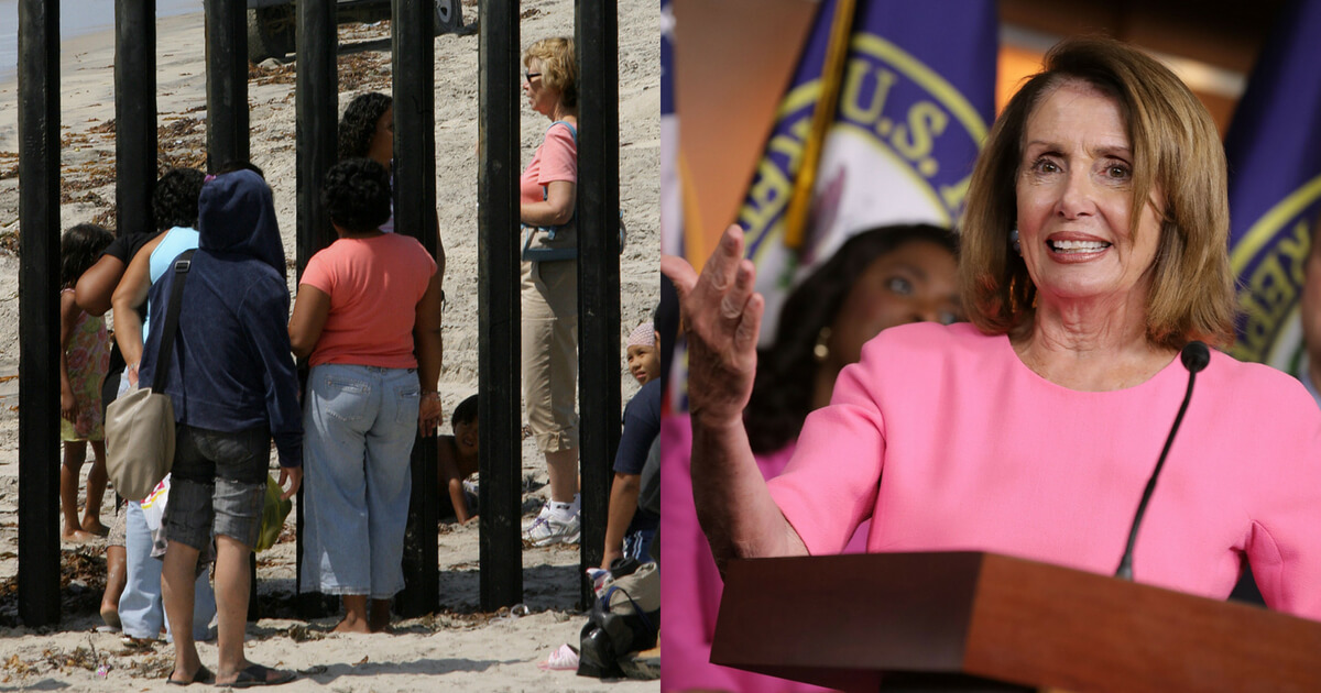 People at the Mexico border fence next to a picture of Nancy Pelosi speaking.