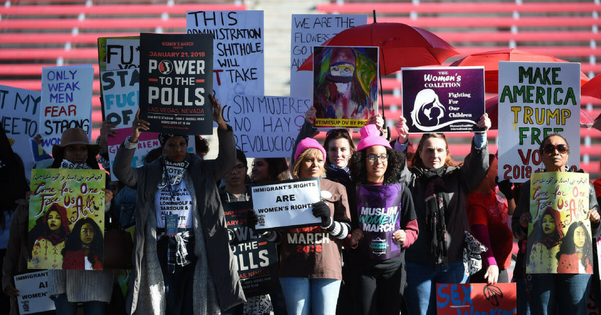 Attendees hold signs onstage during the Women's March 'Power to the Polls' voter registration tour launch at Sam Boyd Stadium on January 21, 2018 in Las Vegas, Nevada.