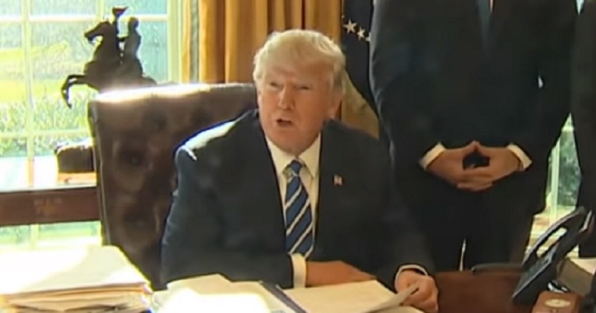 Trump seated in the Oval Office.