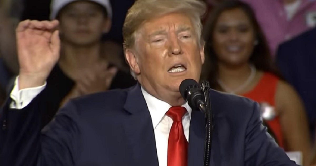 Trump gestures from podium.
