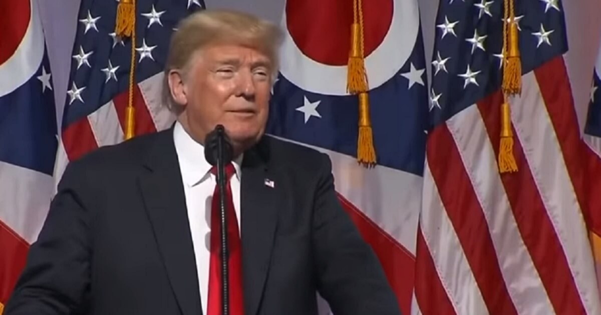 Trump with backdrop of American and Ohio state flags.
