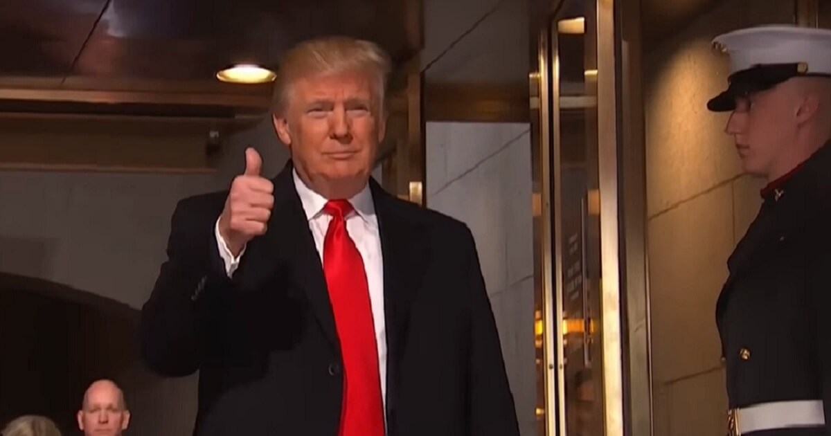 Trump gives thumbs up sign.