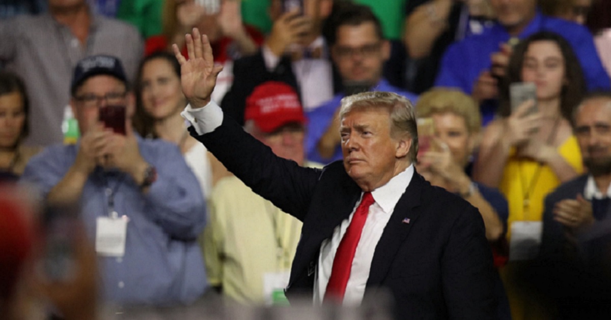 President Trump waving in a crowd.