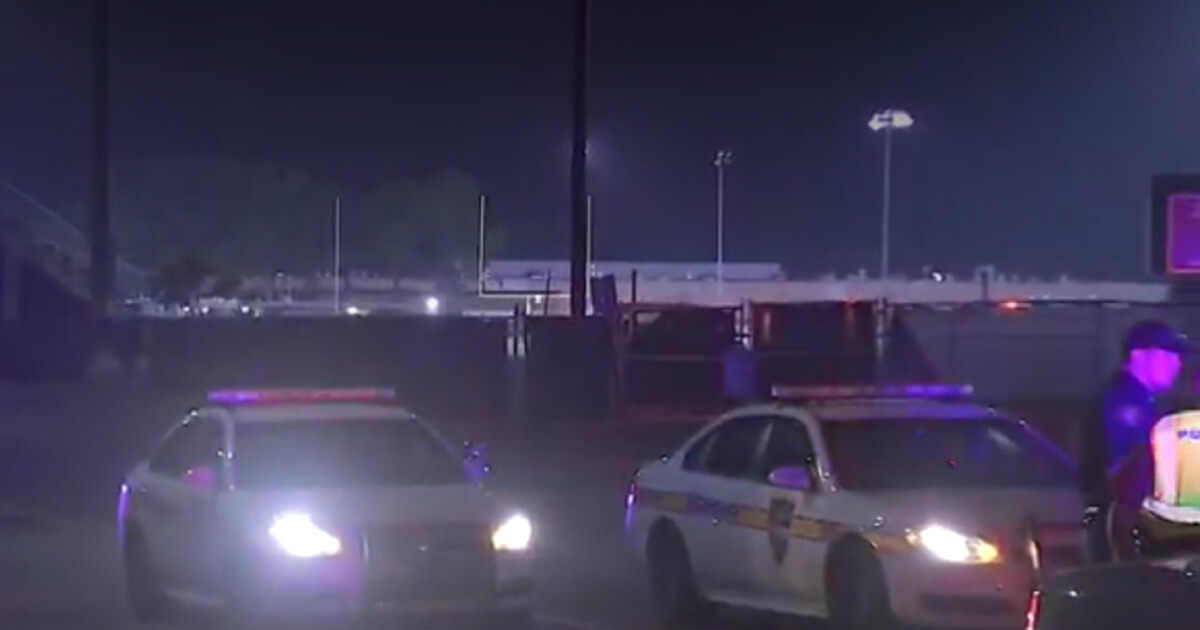 Police gather outside the scene of a shooting at a high school football game near Jacksonville, Fla., left one dead and two injured