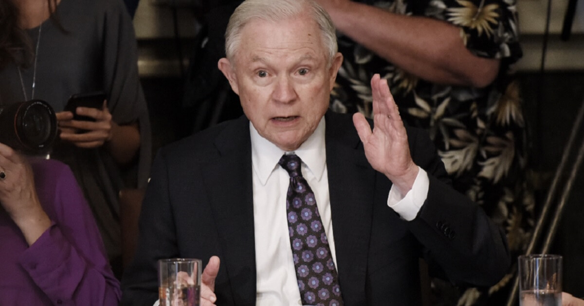 Jeff Sessions raises his hand while apparently raising his voice.