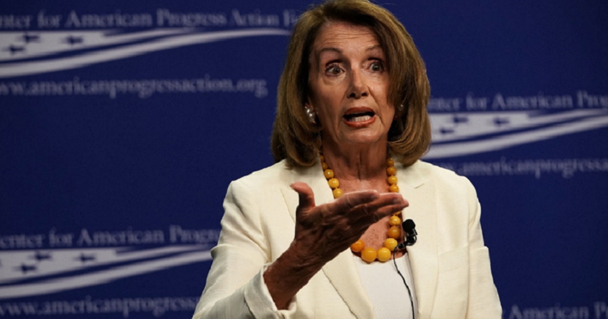 Pelosi gestures while speaking on a stage