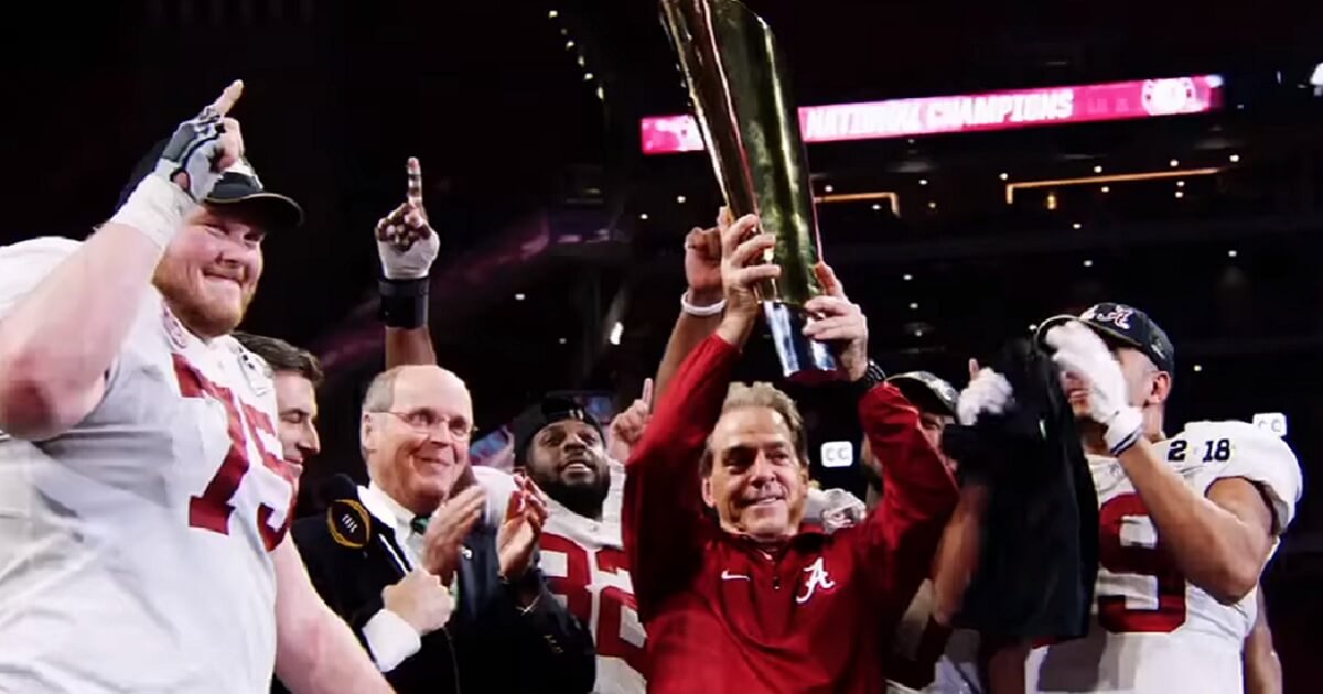 Nick Saban hosts trophy surrounded by players