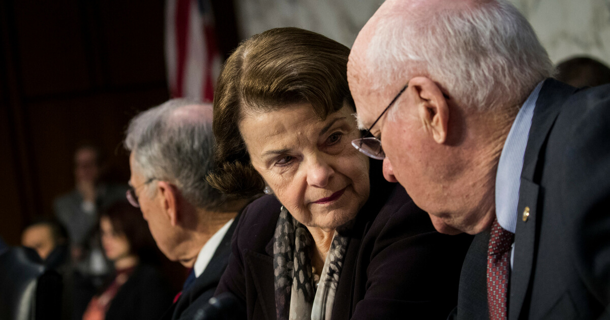 Ranking member Sen. Dianne Feinstein (D-CA), and Sen. Patrick Leahy (D-VT) talk with each other during a Senate Judiciary Committee hearing concerning firearm accessory regulation and enforcing federal and state reporting to the National Instant Criminal Background Check System on Capitol Hill, December 6, 2017, in Washington, D.C.