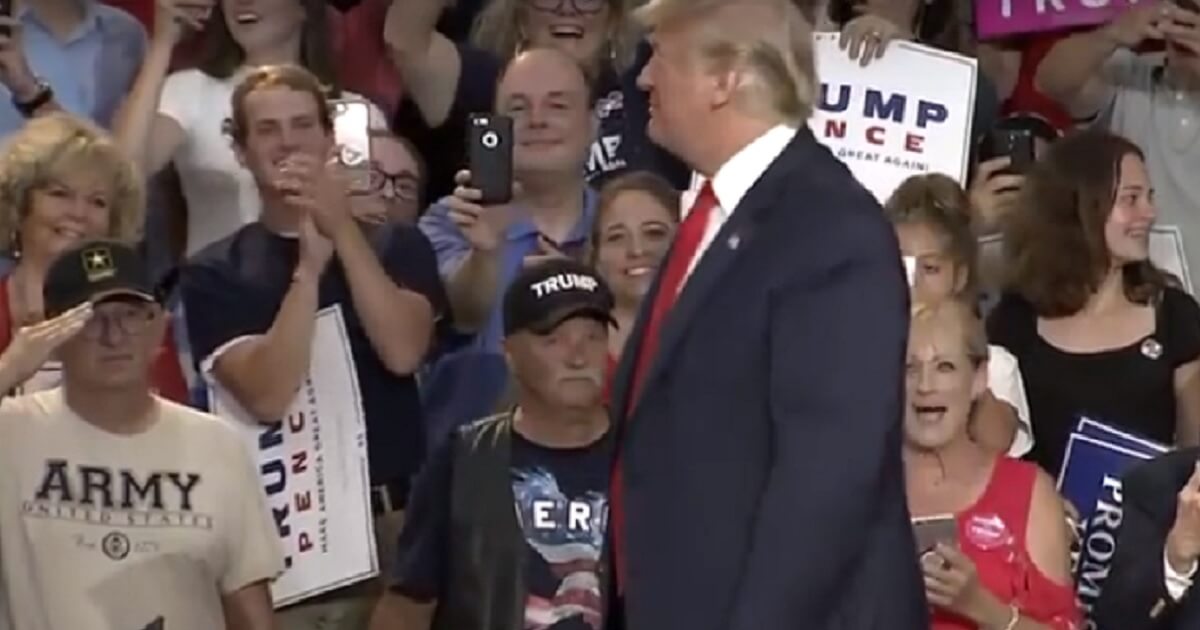 Trump turning toward crowd where man is saluting