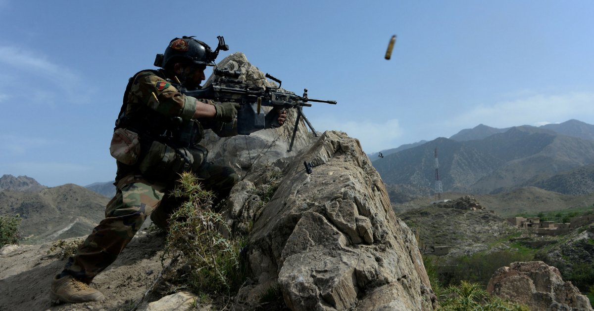 Afghan security force personnel fires gun on mountain top