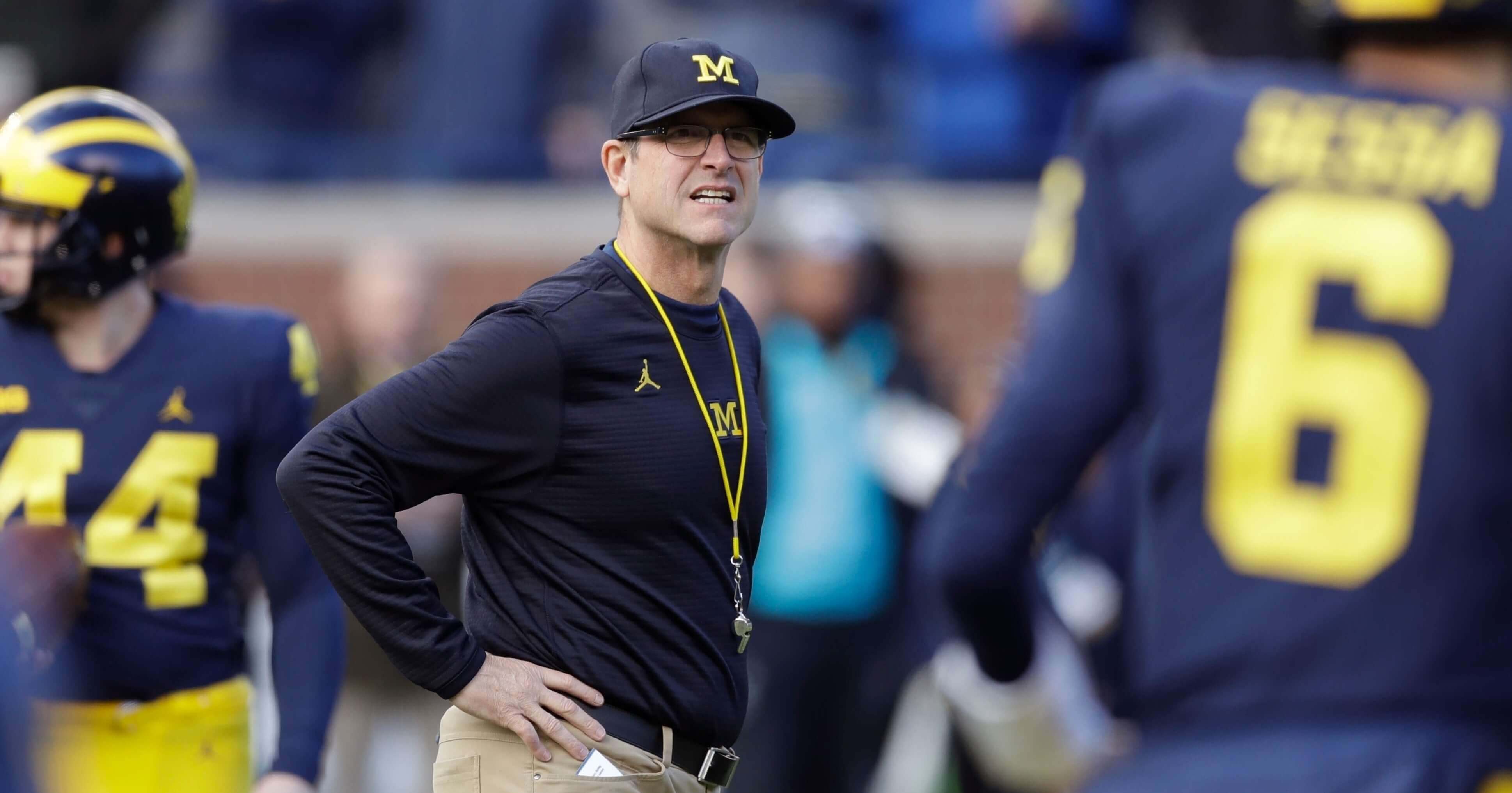 In this Nov. 25, 2017, file photo, Michigan coach Jim Harbaugh watches players warm up for an NCAA college football game against Ohio State in Ann Arbor, Mich.