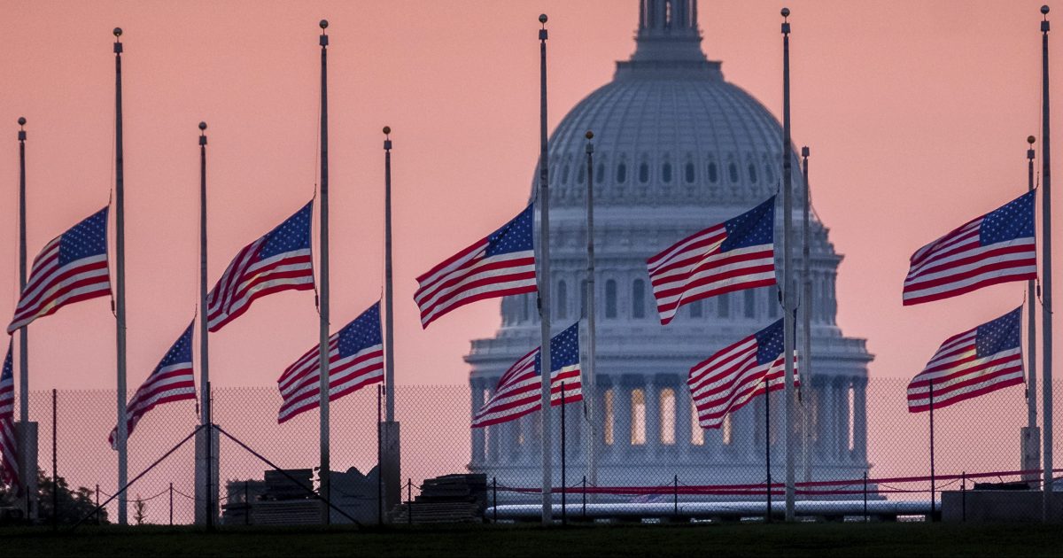 Flags flying a half-staff in honor of Sen. John McCain, R-Ariz., frame the U.S. Capital at daybreak in Washington on Sunday.