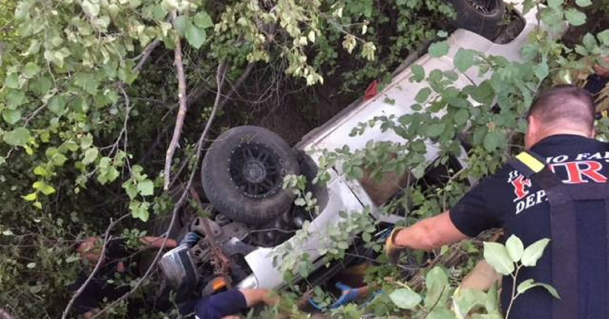 A flipped over car at the bottom of a ravine.