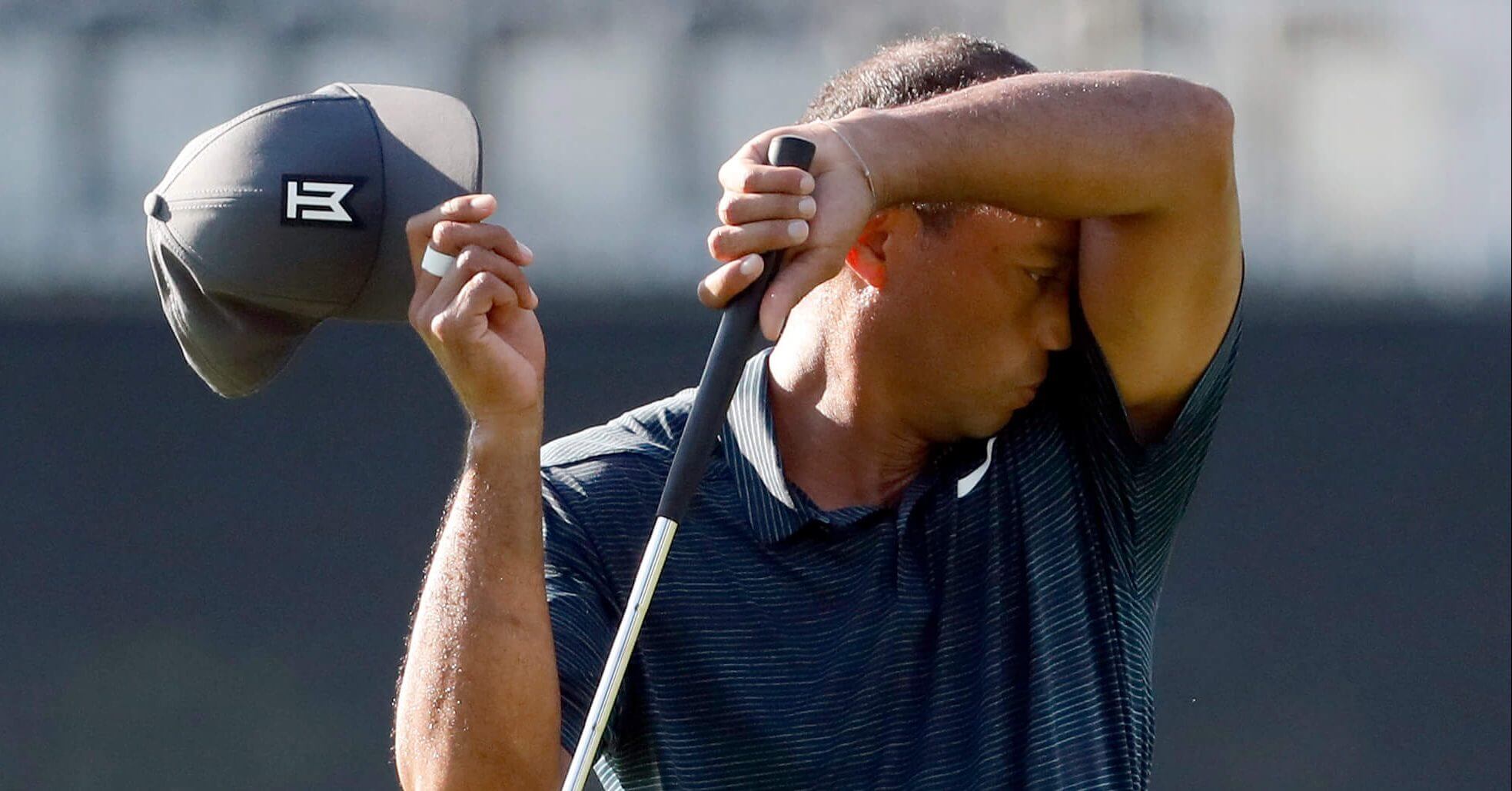 Tiger Woods wipes off his face on the10th green during the first round of the PGA Championship golf tournament at Bellerive Country Club, Thursday, Aug. 9, 2018, in St. Louis.