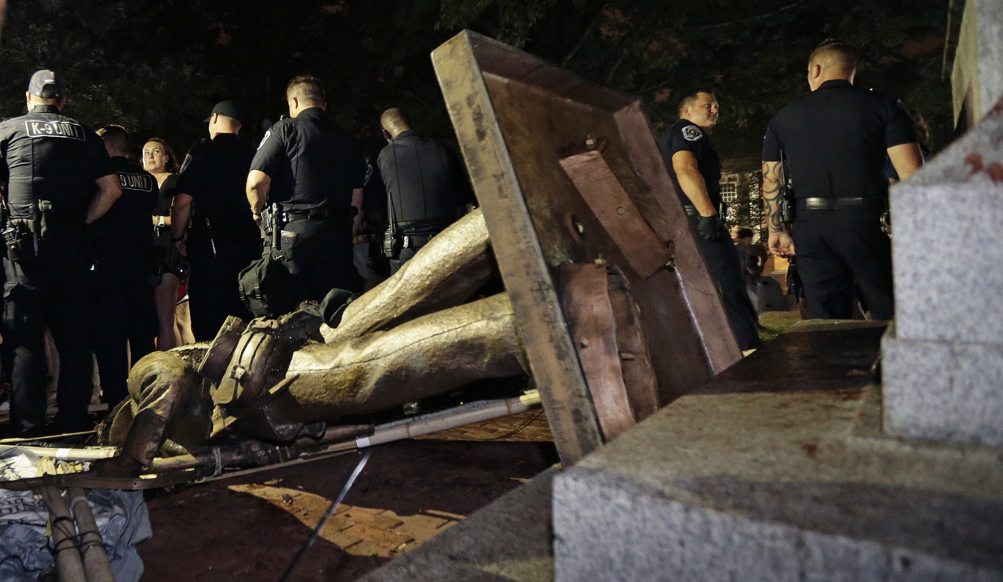 Police stand guard after the Confederate statue known as Silent Sam was toppled by protesters on campus at the University of North Carolina in Chapel Hill, N.C., on Aug. 20, 2018.