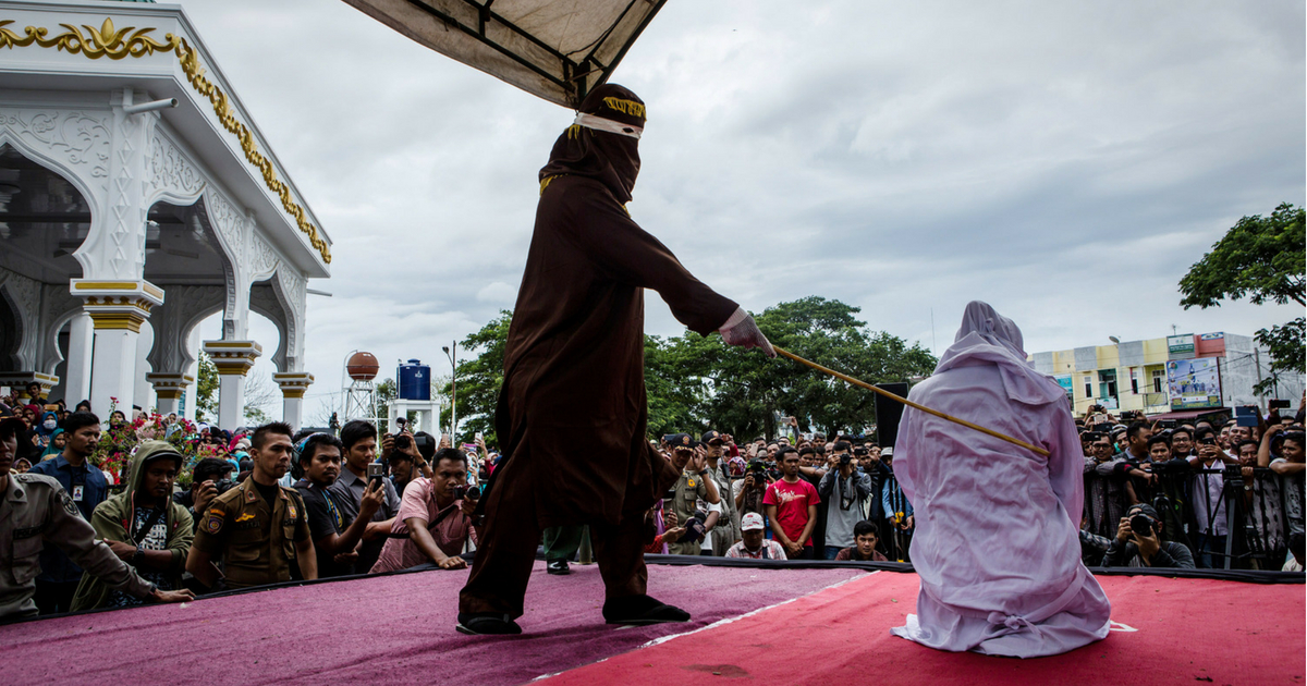 Woman is caned in Indonesia while crowd watches