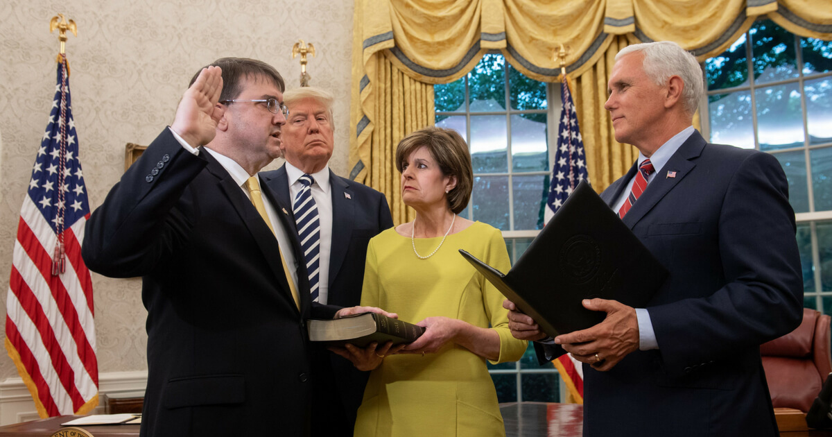 President Donald Trump stands alongside Robert Wilkie (L) as he is sworn-in alongside his wife, Julia (2R), as Secretary of Veterans Affairs by US Vice President Mike Pence in the Oval Office